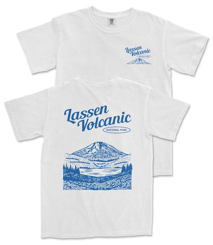A white t-shirt with a graphic design depicting a mountain landscape and a lake, along with the text "Lassen Volcanic National Park" printed on it.