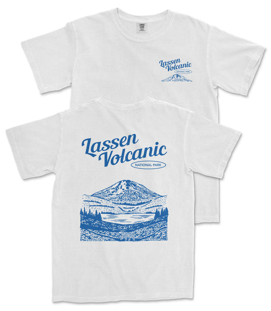 A white t-shirt with a graphic design depicting a mountain landscape and a lake, along with the text "Lassen Volcanic National Park" printed on it.