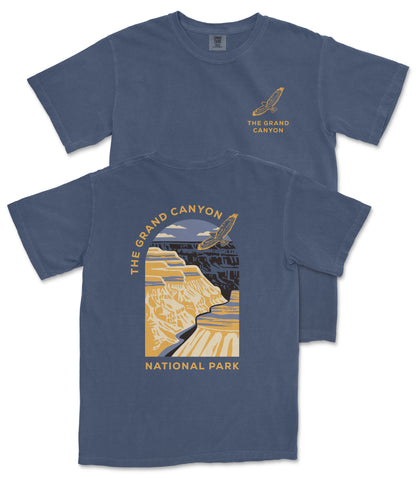 A blue t-shirt with a graphic design depicting the Grand Canyon, featuring a yellow and black color scheme.